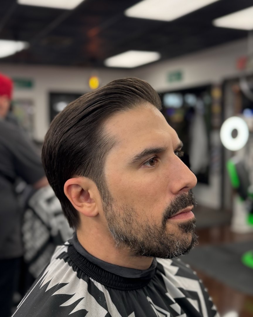 Slicked-back cut with a sculpted beard